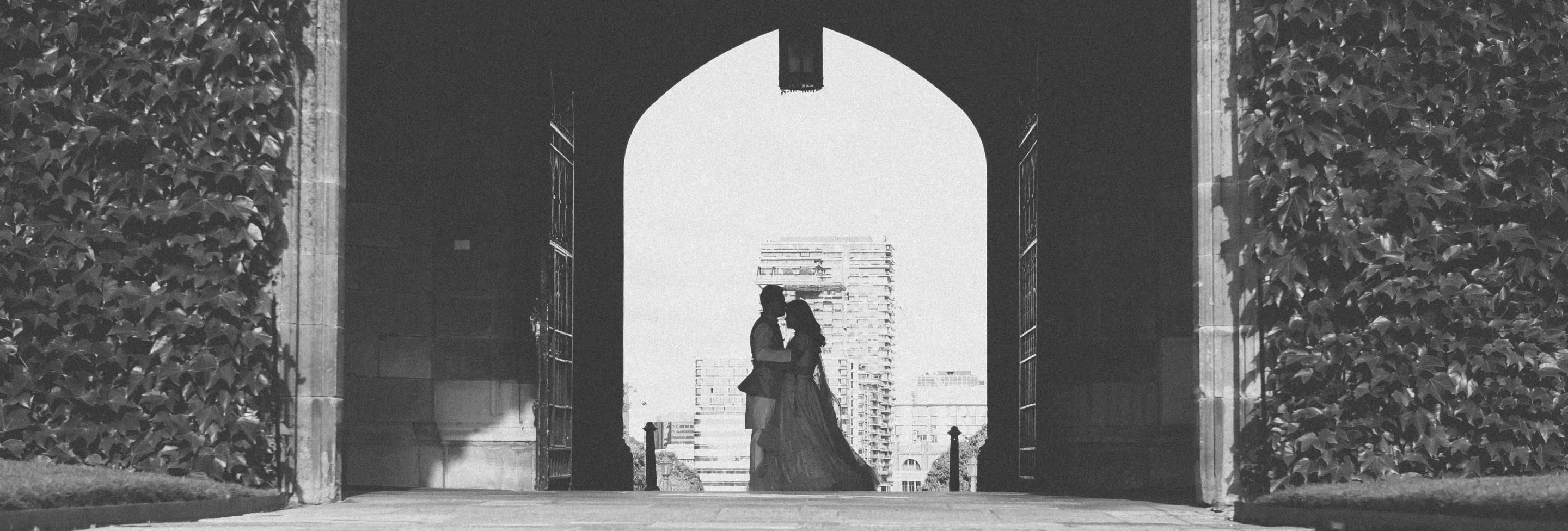 Couple silhouetted in a stone archway during a Grand House session