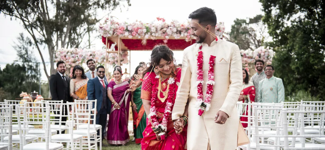 Bride and groom walking an aisle after a floral outdoor ceremony